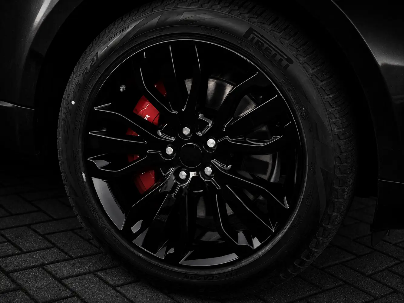 Gloss black alloy wheels with red brake calipers on a Range Rover, AutoPerfect Stone